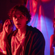 Teens bathed in red light prepare to fight zombies in Unhuman.